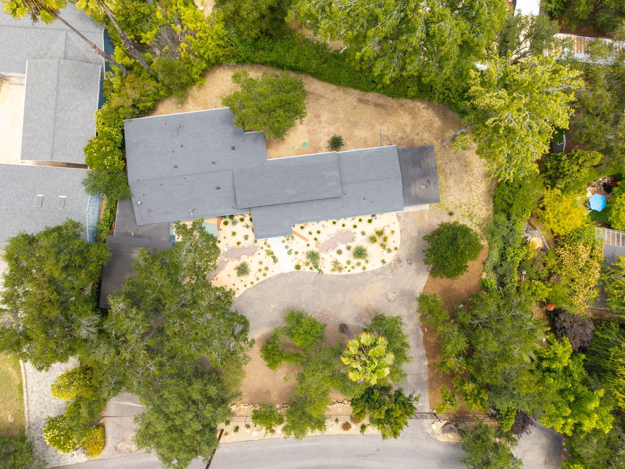 Aerial view showing the nearly half-acre lot and professionally designed front landscape